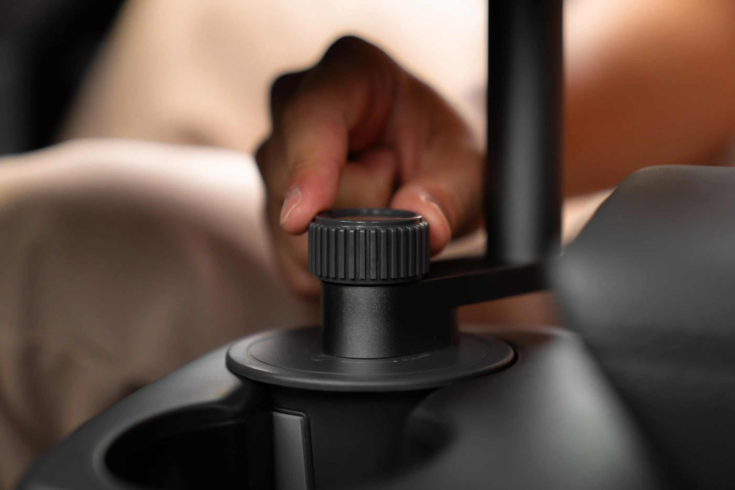 Makro des geriffelten Klemmrads, mit dem der Standfuß im Cupholder der Mittelkonsole verspannt wird