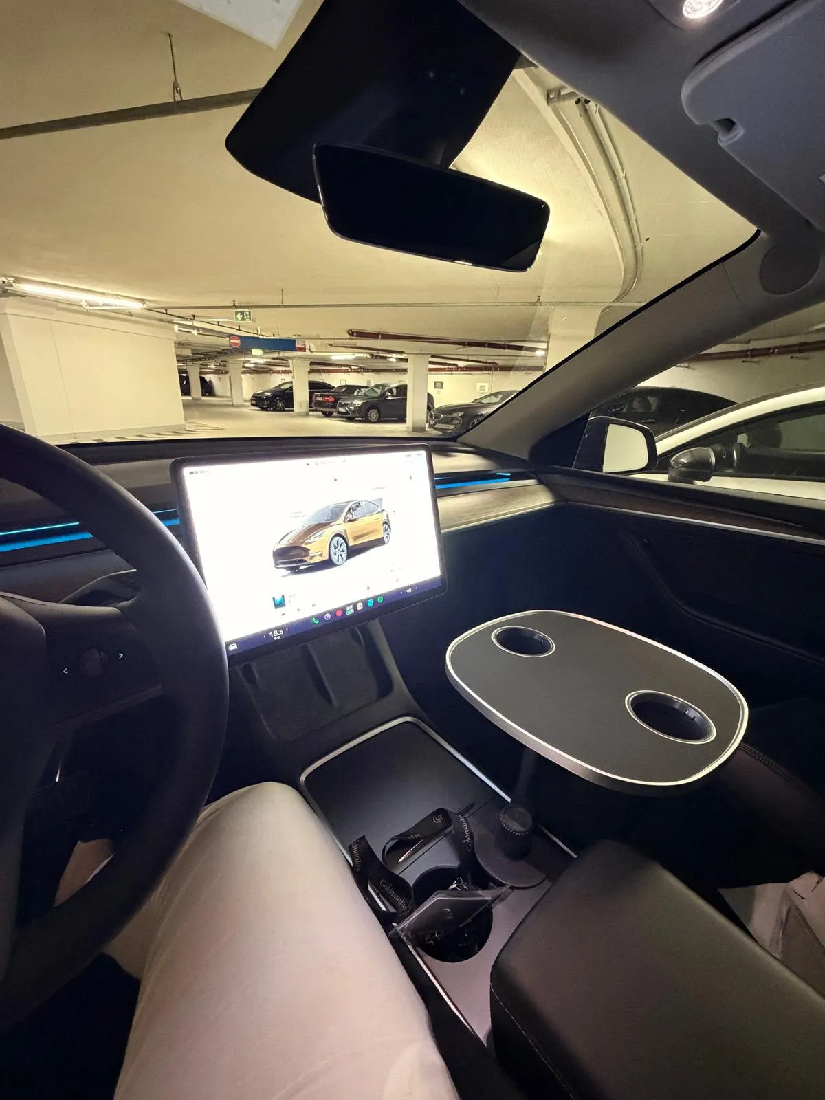 Kundenfoto: schwarze Tischplatte über der Mittelkonsole eines Tesla Model Y im Parkhaus